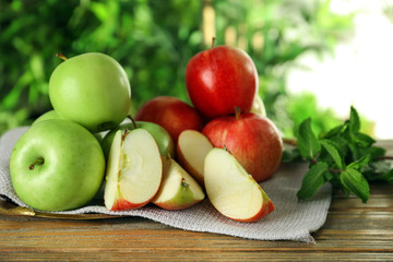Cut and whole ripe fresh apples on wooden table