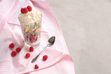 Delicious fruit salad in glass on grey table