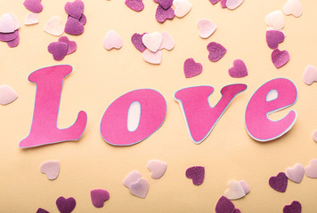 Word LOVE with confetti on light background
