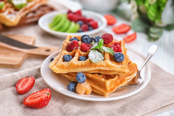 Delicious waffles with berries on plate