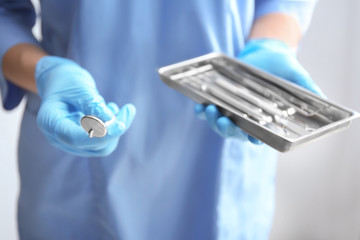 Dentist holding tray with stainless tools, closeup