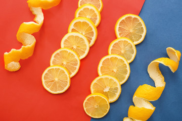 Lemon slices and peel on color background, top view