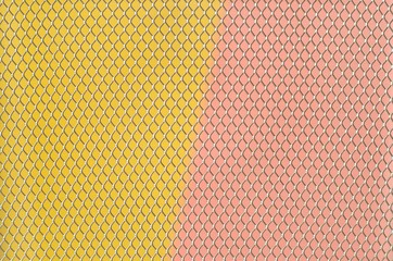 Colorful papers which are yellow and pink with partial focus of the grid pattern of paper bin that...