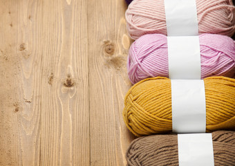 colorful wool threads for knitting on wooden background