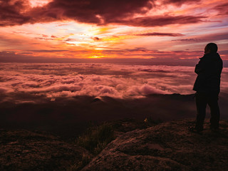 Traveler stand on Rocky cilff with sunsire sky and beautiful cloud sea on 