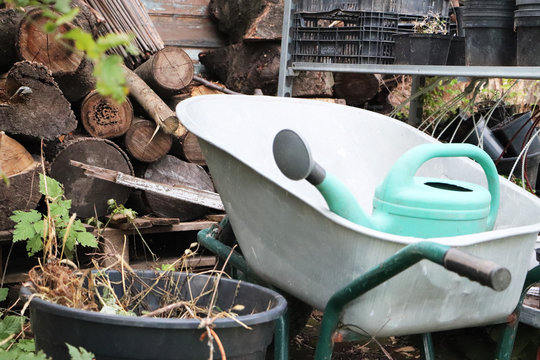Gardening equipment: cart, watering can, crates, fertilizers and flowers