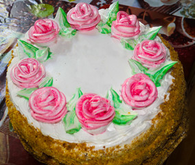 Tasty big cake decoreted with cream roses close-up