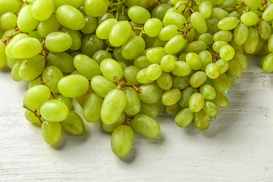 Ripe juicy grapes on white wooden table