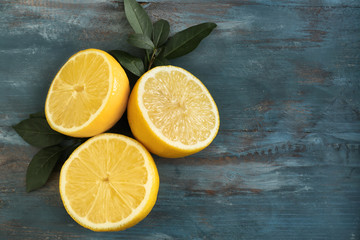 Cut ripe lemons on wooden background