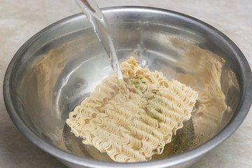 Instant noodles in a plate, covered with boiling water, junk food