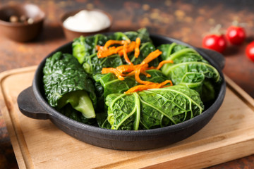 Pan with stuffed cabbage leaves on wooden board