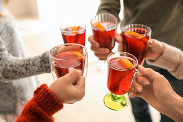 Friends drinking delicious mulled wine at party