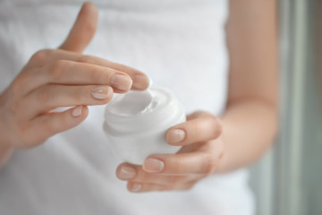 Woman applying body cream, closeup