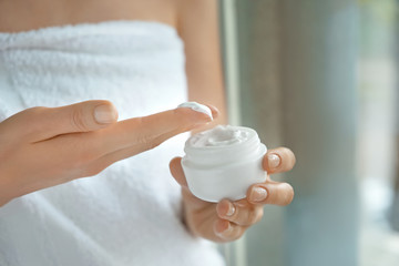 Woman applying body cream, closeup