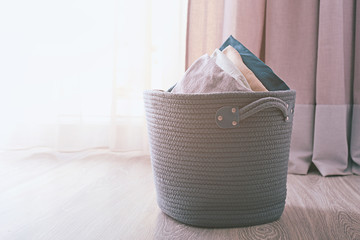 Laundry basket with folded clothes on floor near window