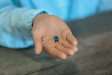 Woman holding pill, closeup