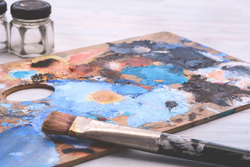 Artist's palette with colorful oil paint strokes and paintbrushes