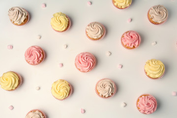 Delicious cupcakes on white background, flat lay
