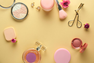 Frame made of decorative cosmetics and accessories on color background