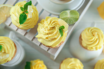 White wooden crate and delicious lemon cupcakes on table, top view