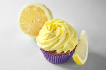 Delicious lemon cupcake on light background