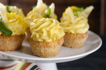 Delicious lemon cupcakes on dessert stand, closeup
