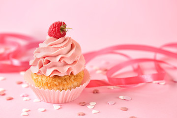 Delicious birthday cupcake on color table