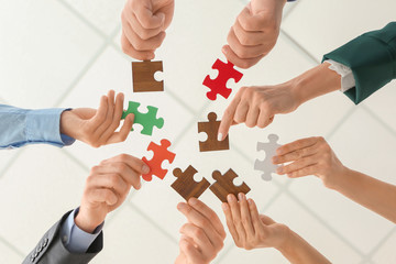 Business team with pieces of puzzle in office, bottom view