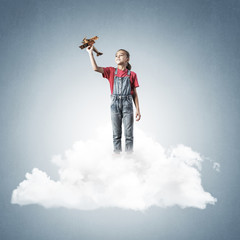 Concept of careless happy childhood with girl dreaming to become
