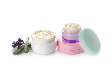 Jars of body cream with aloe vera and flowers on white background