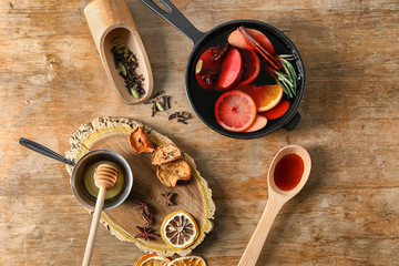 Saucepan of delicious mulled wine with ingredients on wooden table
