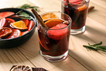 Glass of delicious mulled wine on wooden table