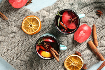 Metal cups of delicious mulled wine on warm plaid