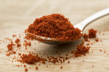 Heap of red paprika powder on a spoon