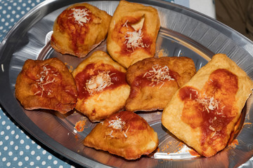 Small fried  pizzas with tomato sauce and cheeese