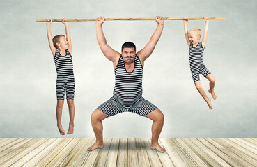 Family of strongman. The father of two sons in vintage costume of athletes perform strength exercises. Family look.