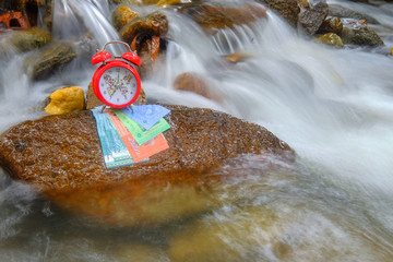 Time is money concept with money and alarm clock on river  .