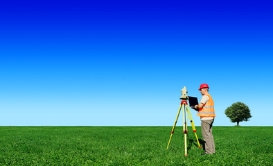 Surveyor on green field