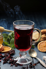 Hot red karkade tea with honey and biscuits. autumn. winter. on blue wooden table
