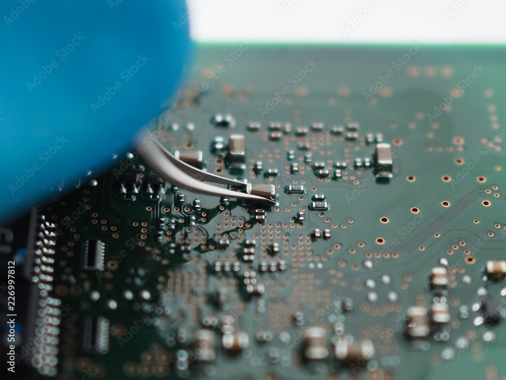 Poster close up short of technician hand assembling inside of part on pcb board