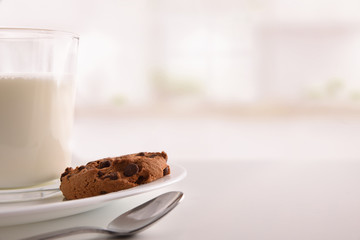 Biscuit with chocolate and glass of milk in kitchen front