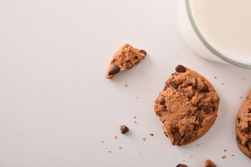 Biscuit with chocolate chips and glass of milk top view
