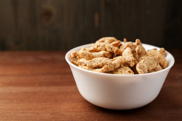 Raw dry soya meat chunks in a white bowl on a wooden table