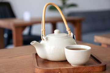 A set of ceramic japanese style teapot on wooden serving tray