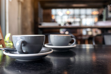 Closeup image of two blue cups of hot latte coffee on vintage wooden table in cafe