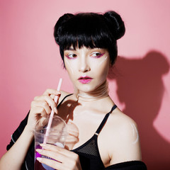 Cyber girl. Beautiful young woman, futuristic style. Portrait of a trendy girl drinking soda