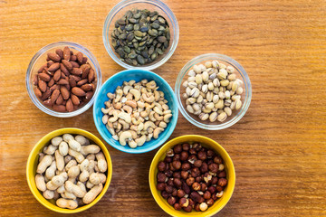 Assortment of mixed nuts on wood table background 