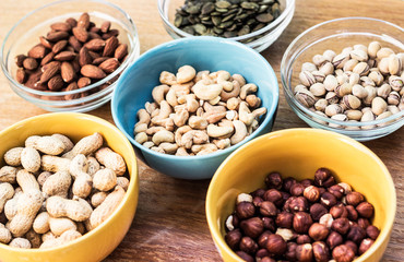 Assortment of mixed nuts on wood table background 