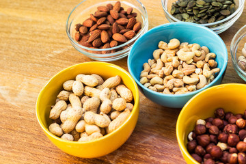 Assortment of mixed nuts on wood table background 