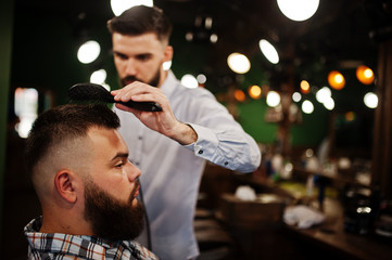 Handsome bearded man at the barbershop, barber at work.